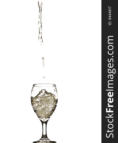 A stream of water splashing into and filling a wine glass. A stream of water splashing into and filling a wine glass.