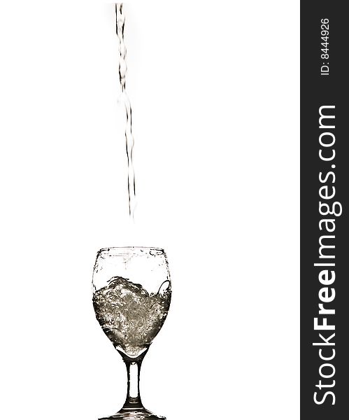 A stream of water splashing into and filling a wine glass. A stream of water splashing into and filling a wine glass.