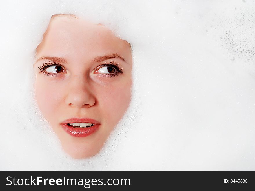 Face of a beautiful woman in white foam. Face of a beautiful woman in white foam