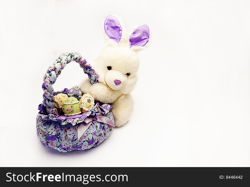 Isolated shot of a basket with easter eggs and bunny holding the basket. Isolated shot of a basket with easter eggs and bunny holding the basket.