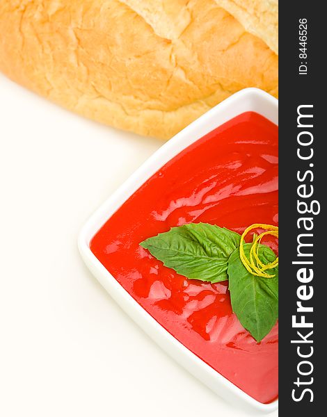 Tomato soup served with basil and bread