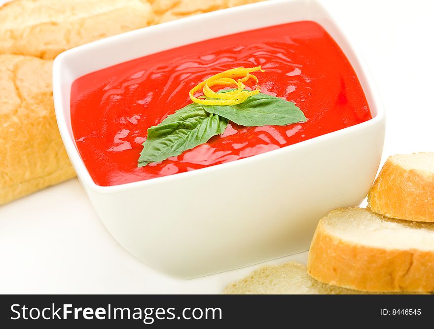 Tomato soup served with basil and bread