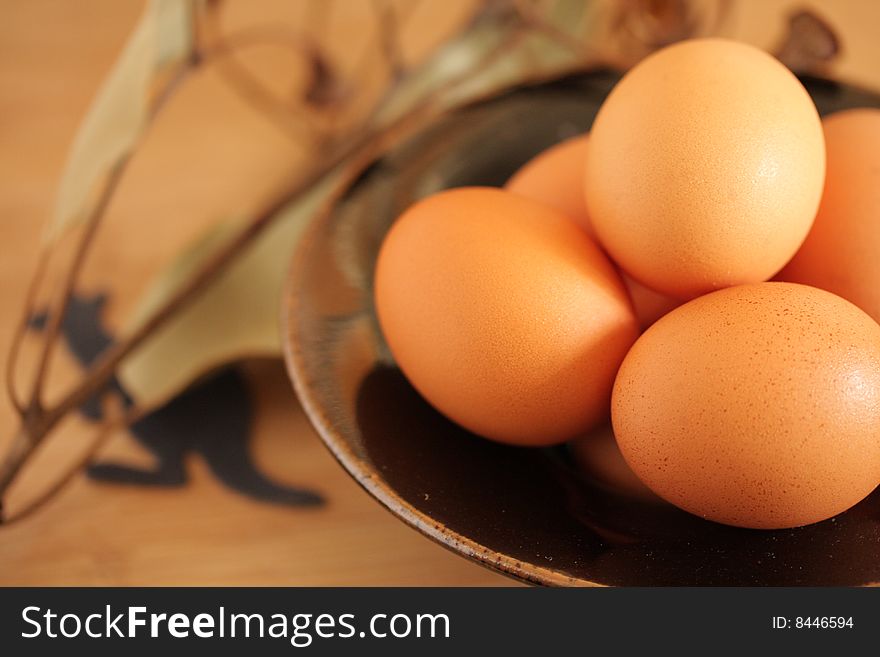 Handmade bowl of fresh australian eggs shown whith a sprig of eucalyptus and kangaroo symbol. Handmade bowl of fresh australian eggs shown whith a sprig of eucalyptus and kangaroo symbol