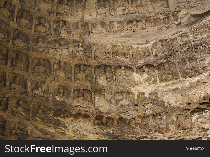 Image of many buddhas on the wall.