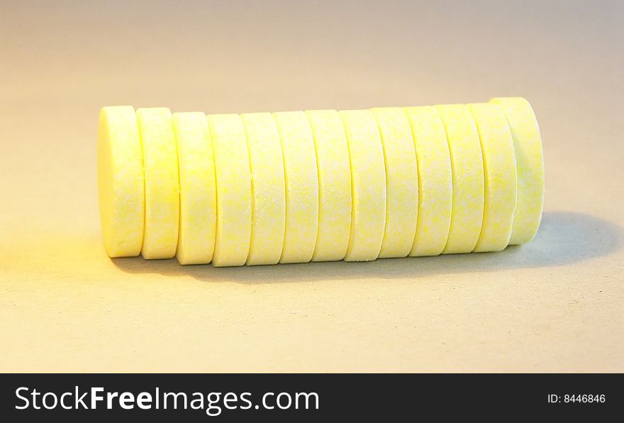 Horizontal stack of yellow effervescent vitamin C tablets, isolated on background. Horizontal stack of yellow effervescent vitamin C tablets, isolated on background