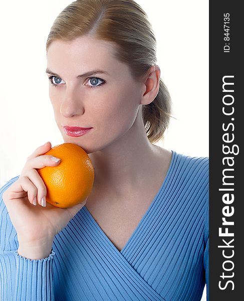 Portrait of the beautiful girl with an orange in hands