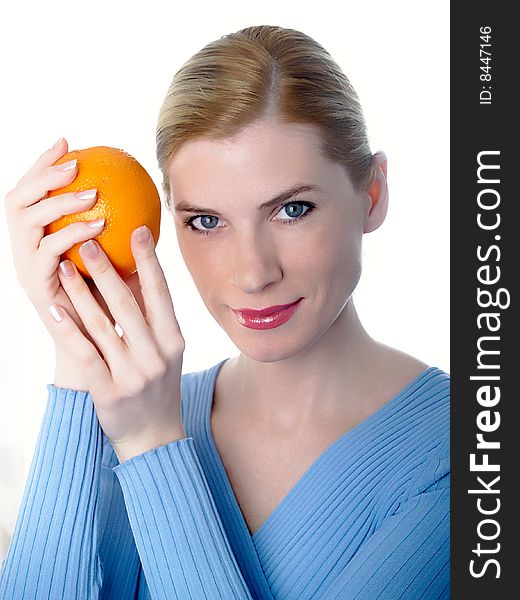 Portrait of the beautiful girl with an orange in hands