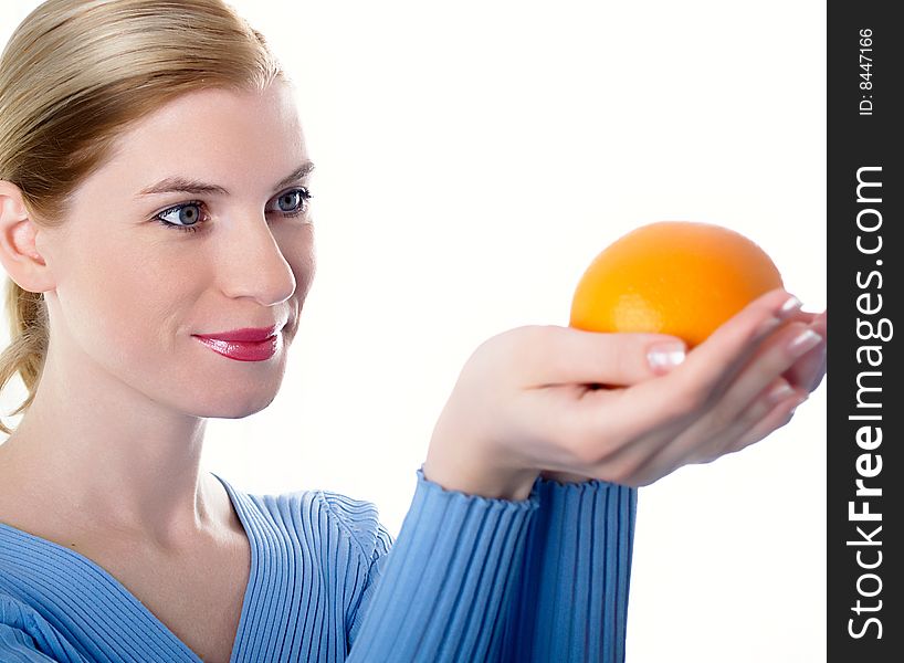 Portrait of the beautiful girl with an orange in hands