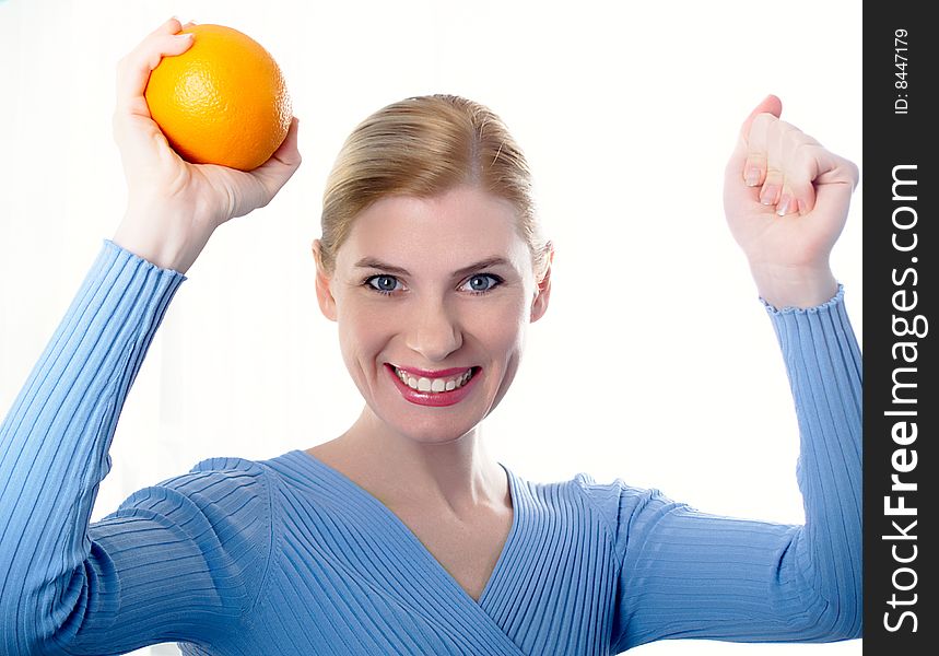 Portrait of the beautiful girl with an orange in hands