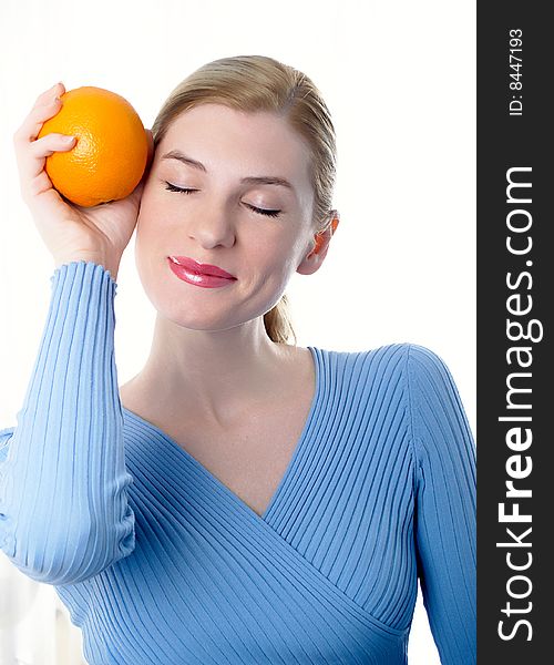 Portrait of the beautiful girl with an orange in hands