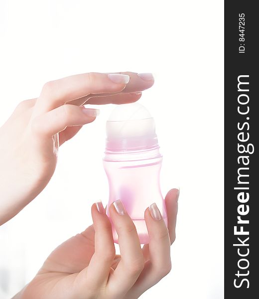 The female hands holds a bottle with perfumery on a white background. The female hands holds a bottle with perfumery on a white background