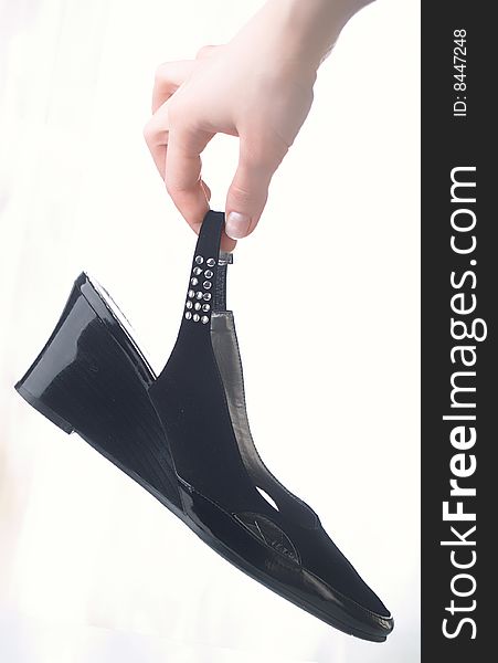 Black shoes in a hand on white background