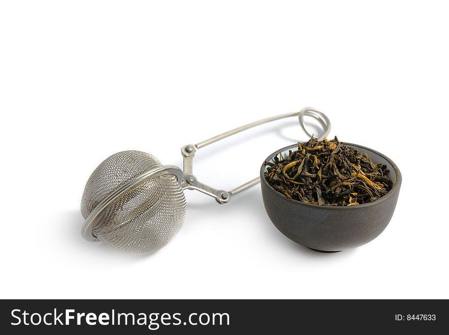 Tea strainer and cup with tea inside isolated on white.