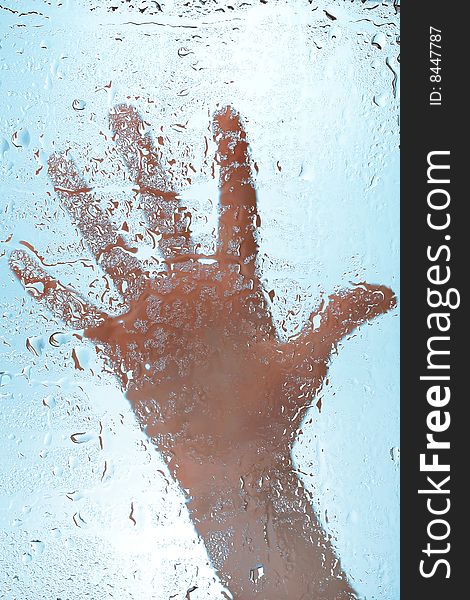 Hand on wet glass surface