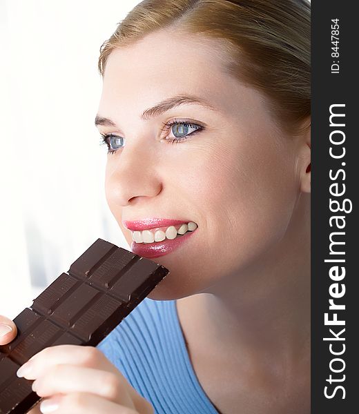 Portrait of the beautiful girl with a chocolate in a hand