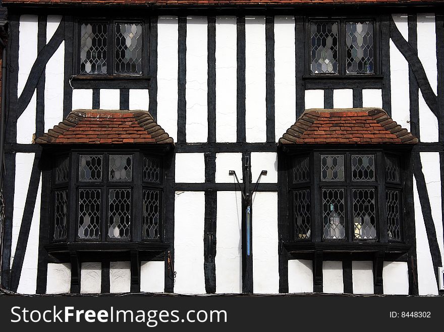 Close crop photo of an ancient Tudor era building in Henley Oxfordshire England with black beams and whitewashed walls. Close crop photo of an ancient Tudor era building in Henley Oxfordshire England with black beams and whitewashed walls