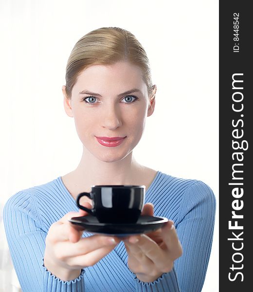 The beautiful girl with a coffee cup in a hand