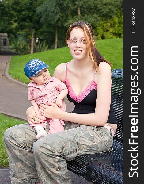 Mother and daughter sitting outside on a park bench