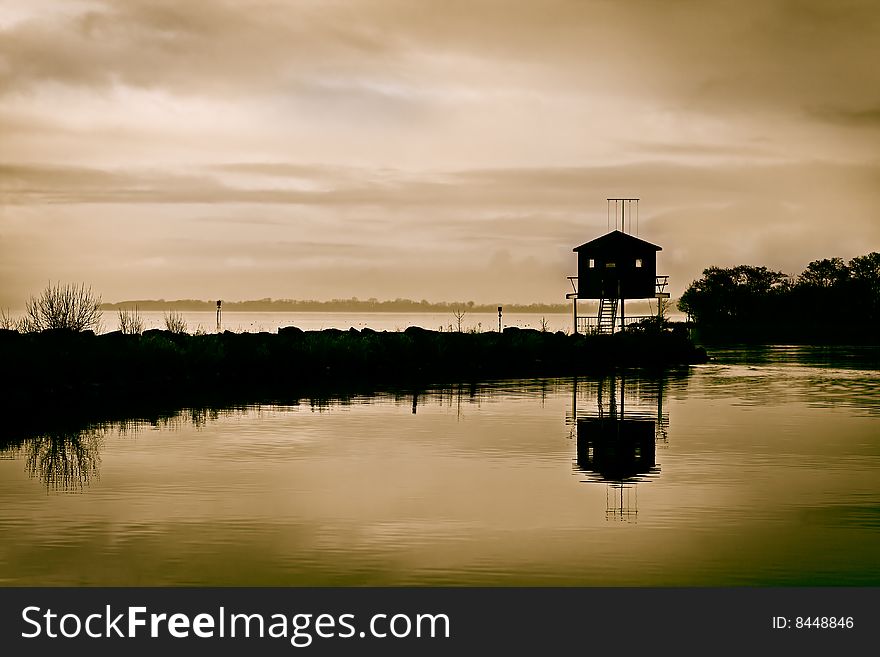 Moody skies above a bird watching hide at twilight. Moody skies above a bird watching hide at twilight