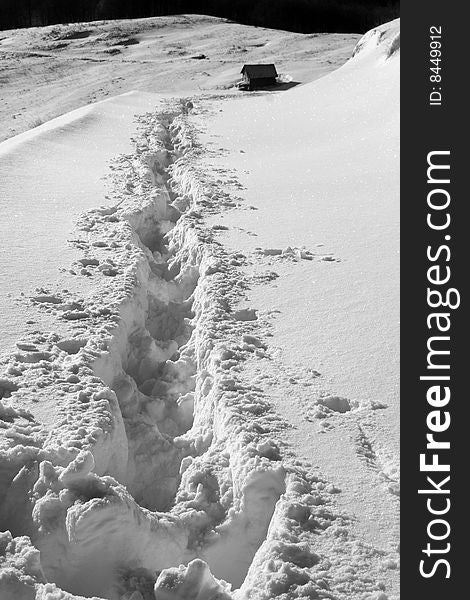 Path through the fluffy pure snow going to an old hut in Ciucas mountain, Romania. Path through the fluffy pure snow going to an old hut in Ciucas mountain, Romania.
