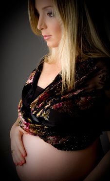 Side View Of Pregnant Female Touching Her Tummy Royalty Free Stock Photography
