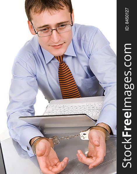 Handsome young businessman bound to laptop with handcuffs. Handsome young businessman bound to laptop with handcuffs