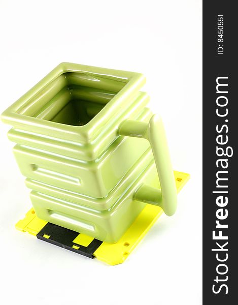 The square mug on a yellow diskette