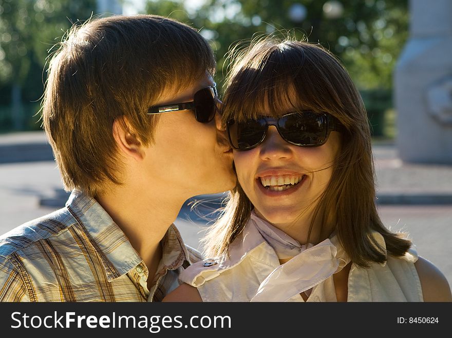Boy Kissing A Happy Girl In Sunglasses