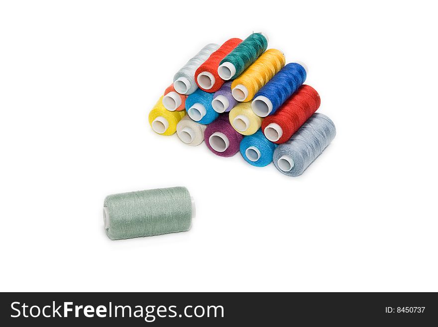 Different colored bobbins on a white background