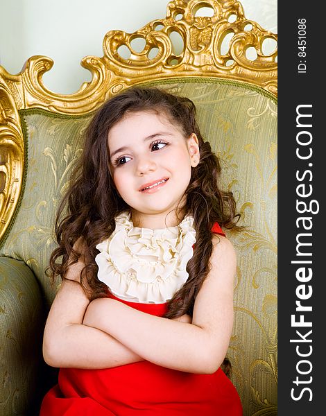 Small girl with long hair in the armchair