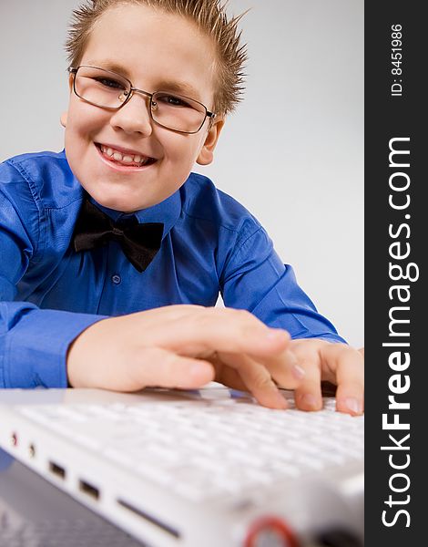 Funny school boy with with fingers on laptop keyboard. Funny school boy with with fingers on laptop keyboard