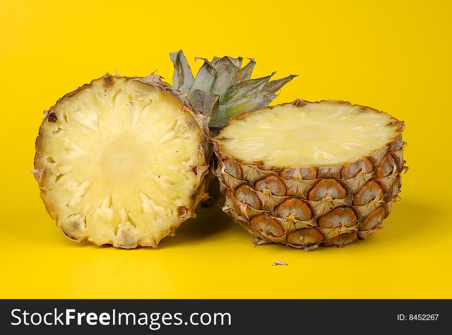 Parts of the big ripe juicy pineapple on a yellow background