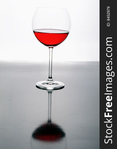 A glass of red wine on grey isolated on white with reflection