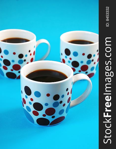 Colorful coffee mugs on blue background