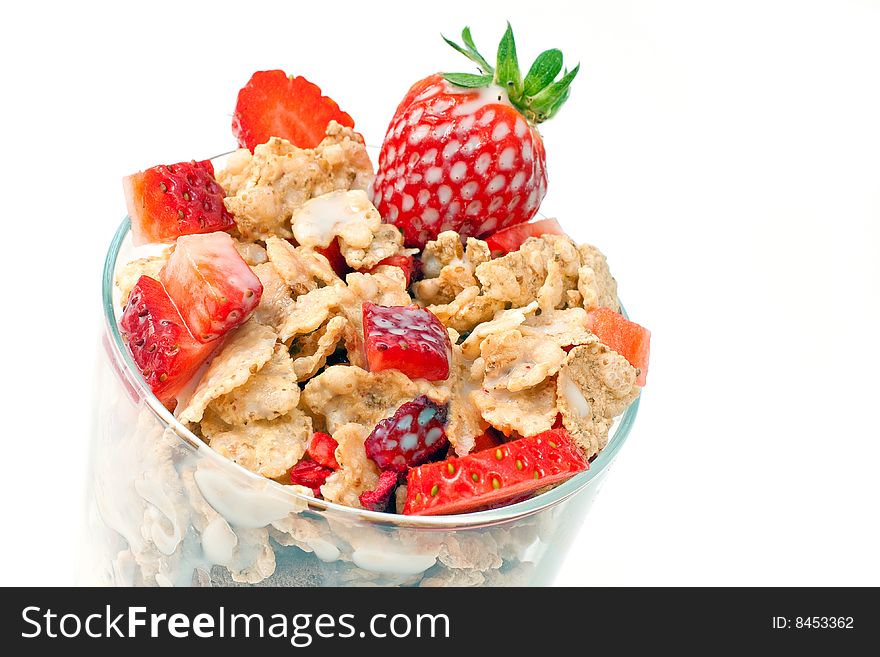 Bowl with corn flakes and strawberry served with milk