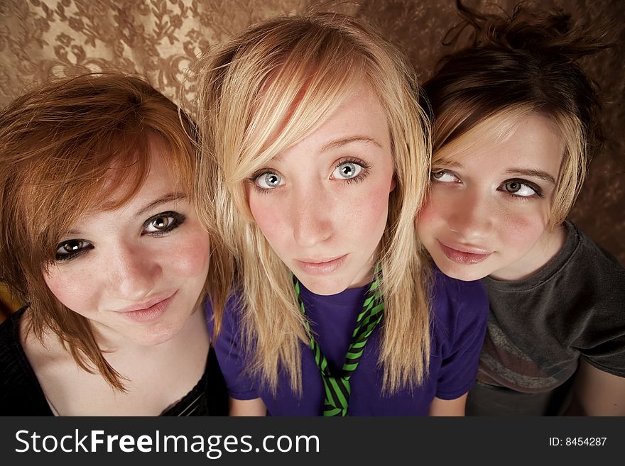 Portrait of three pretty young girls on a gold background. Portrait of three pretty young girls on a gold background