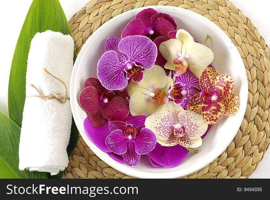 Close up of spa towels, leaf with colorful orchid