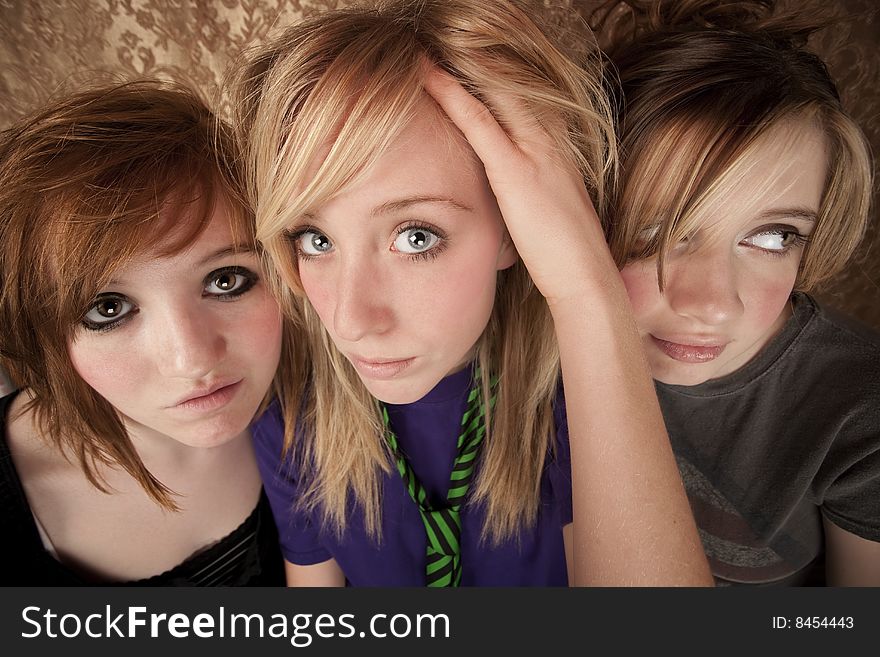 Portrait of three pretty young girls on a gold background. Portrait of three pretty young girls on a gold background