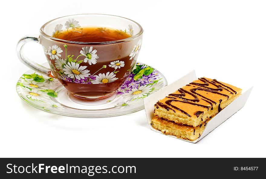 Cap of tea on saucer with cake on white