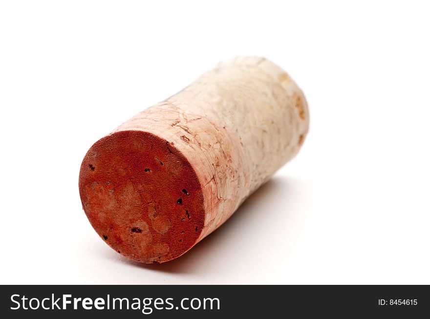 A horizontal shallow focus closeup of a red wine cork on white