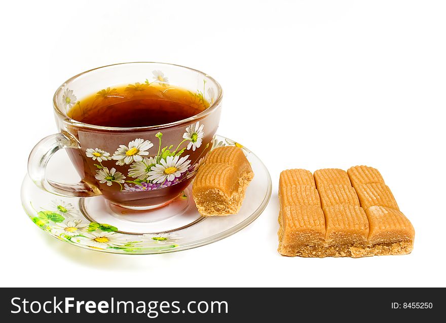 Cap of tea on saucer with toffee on white