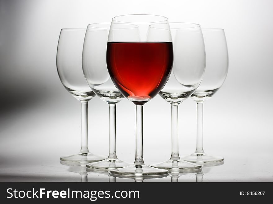 Five wine glasses on grey background