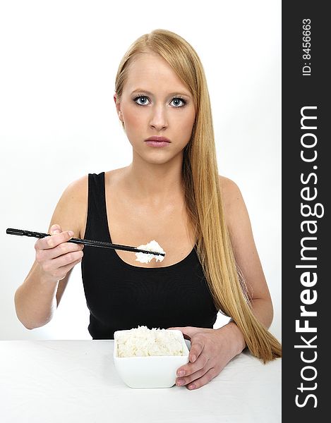 Blond woman use chopsticks eating Rice. Blond woman use chopsticks eating Rice