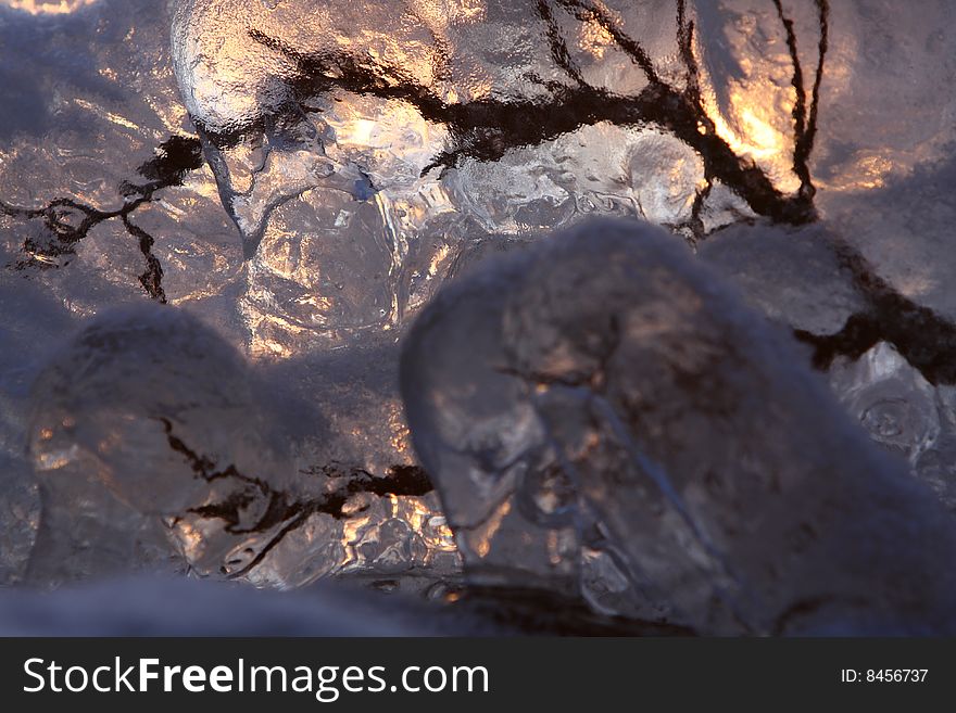 Sunset over frozen lake in winter, Finland, frozen branch detail