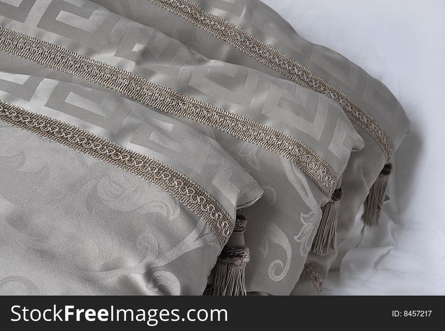 Three decorative beige pillows with tassels
