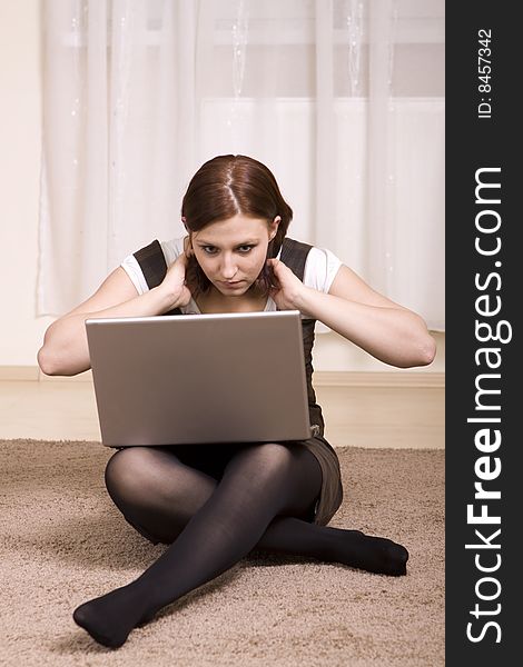 Woman with laptop on carpet