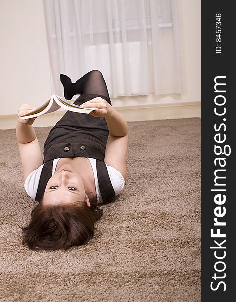 Woman reading a book on carpet. Woman reading a book on carpet