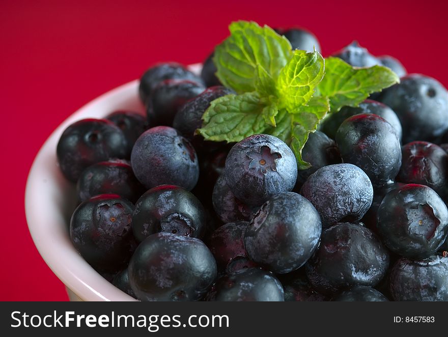 Blueberries In Bowl On Red Background