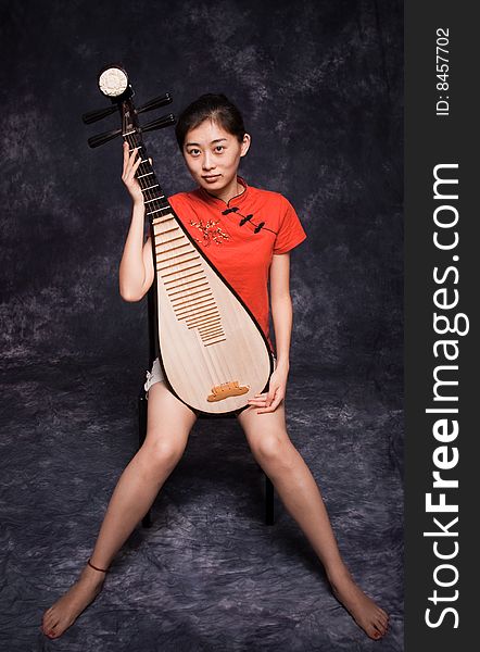 Chinese lute player in red shirt on performance. Chinese lute player in red shirt on performance