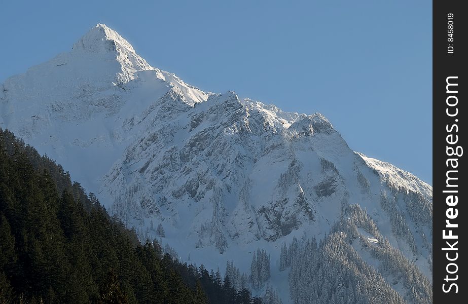 A lofty mountain is covered with fresh snow. A lofty mountain is covered with fresh snow